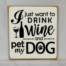 Load image into Gallery viewer, “I Just Want to Drink Wine and Pet My Dog” Funny handcrafted wood sign with an adorable paw print stamp and an image of a wine glass and bottle, 12x12 inches white font over Antique White. Rustic modern farmhouse home décor